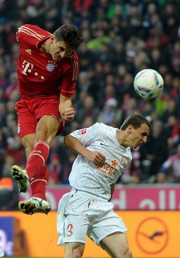 Bayern Munich's striker Mario Gomez (L) and Mainz's defender Zdenek Pospech jump for the ball