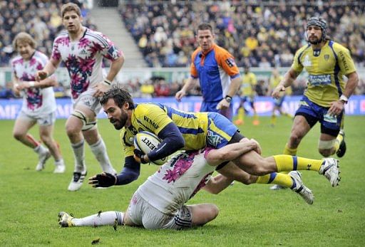 Clermont's fly-half Brock James is tackled by a Stade Francais player