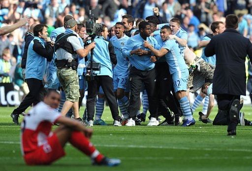 Manchester City's players and supporters celebrate on the pitch after their 3-2 victory Manchester City's players and supporters celebrate on the pitch after their 3-2 victory
