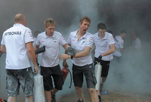 Racing crews join forces to put out the fire at the Williams racing pit stand on Sunday Racing crews join forces to put out the fire at the Williams racing pit stand on Sunday