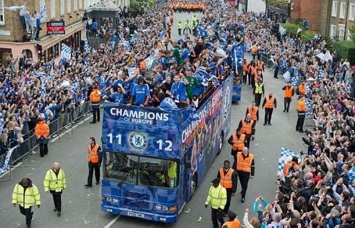 Chelsea players wave to fans as they ride during an open-top bus parade Chelsea players wave to fans as they ride during an open-top bus parade