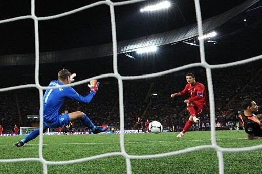 Portuguese forward Cristiano Ronaldo (C) scores past Dutch goalkeeper Maarten Stekelenburg Portuguese forward Cristiano Ronaldo (C) scores past Dutch goalkeeper Maarten Stekelenburg