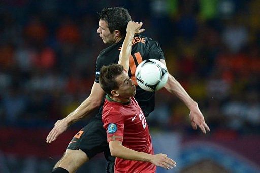 Dutch forward Robin van Persie (back) and Portuguese defender Joao Pereira jump for a header Dutch forward Robin van Persie (back) and Portuguese defender Joao Pereira jump for a header
