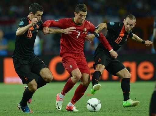 Portuguese forward Cristiano Ronaldo vies with Dutch midfielder Wesley Sneijder (R) and Dutch forward Robin van Persie Portuguese forward Cristiano Ronaldo vies with Dutch midfielder Wesley Sneijder (R) and Dutch forward Robin van Persie