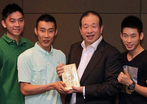 Lee Chong Wei (2ndL) and CEO of Peninsular Gold limited Andrew Kam (2ndR) hold a bar of gold Lee Chong Wei (2ndL) and CEO of Peninsular Gold limited Andrew Kam (2ndR) hold a bar of gold
