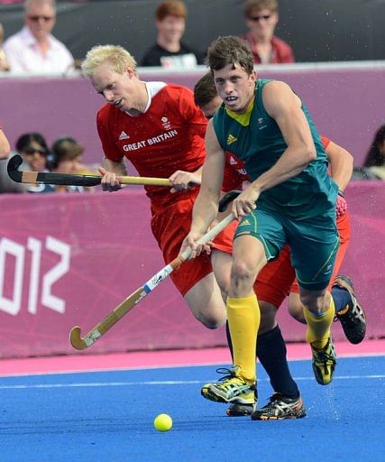 Australia's midfielder Simon Orchard (R) runs with the ball ahead of Britain's defenders Australia's midfielder Simon Orchard (R) runs with the ball ahead of Britain's defenders