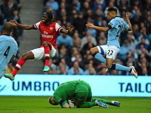 Manchester City's goalkeeper Joe Hart (ground) saves from Arsenal's Gervinho (Top L) Manchester City's goalkeeper Joe Hart (ground) saves from Arsenal's Gervinho (Top L)