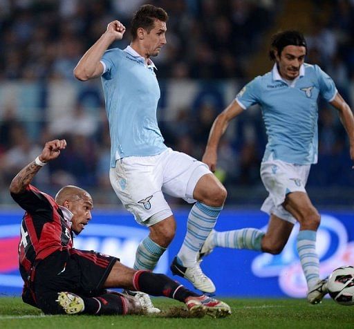 AC Milan's midfielder Nigel de Jong (L) slides to score against Lazio AC Milan's midfielder Nigel de Jong (L) slides to score against Lazio