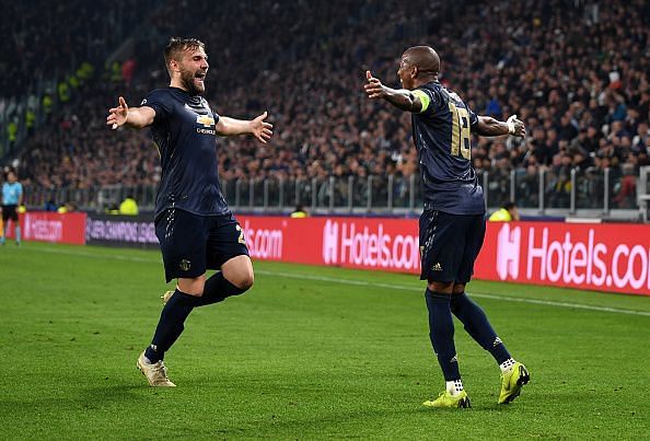 Shaw celebrates one of United's two goals with defensive counterpart Ashley Young in Turin