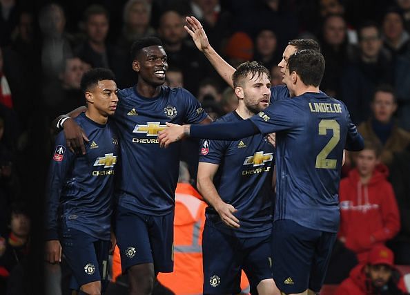 Pogba and Lingard (far left) celebrate with some of their teammates during a memorable fourth-round win