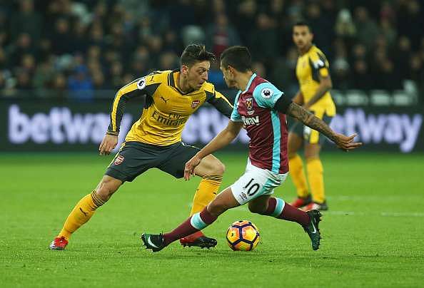 LONDON, ENGLAND - DECEMBER 03:  Mesut Oezil of Arsenal battles for the ball with Manuel Lanzini of West Ham during the Premier League match between West Ham United and Arsenal at London Stadium on December 3, 2016 in London, England.  (Photo by Charlie Crowhurst/Getty Images)